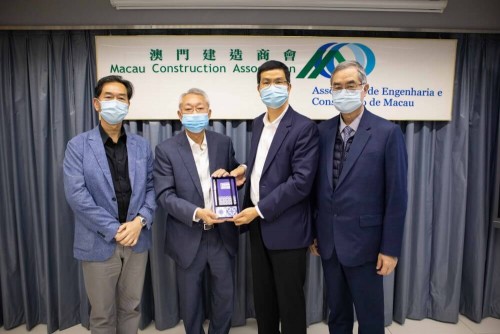 MUR Chairperson of the Board of Directors Peter Lam Kam Seng (second from left) gives a souvenir to Macau Construction Association President Lo Chi Cheong (second from right).