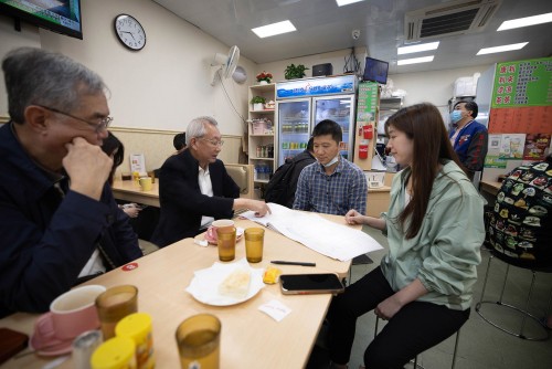 Representatives of MUR brief a business owner in Iao Hon Estate about the local area plan.